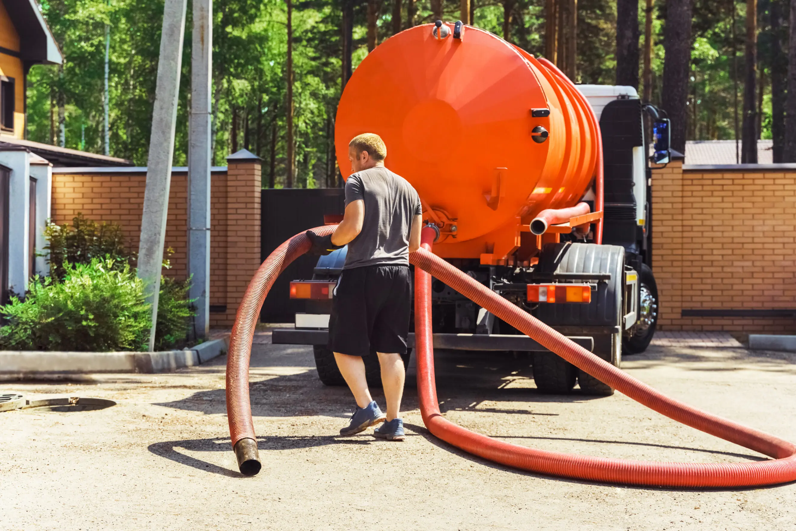 Septic tank pumping, view of man installing submersible sewage pump. Pumping out sewage from a septic tank